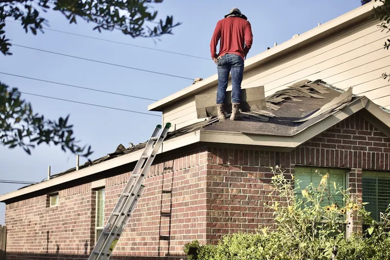 Professional roofer working on a residential roof in Wick Park
